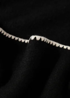 Stickad tröja med dekorativa sömmar